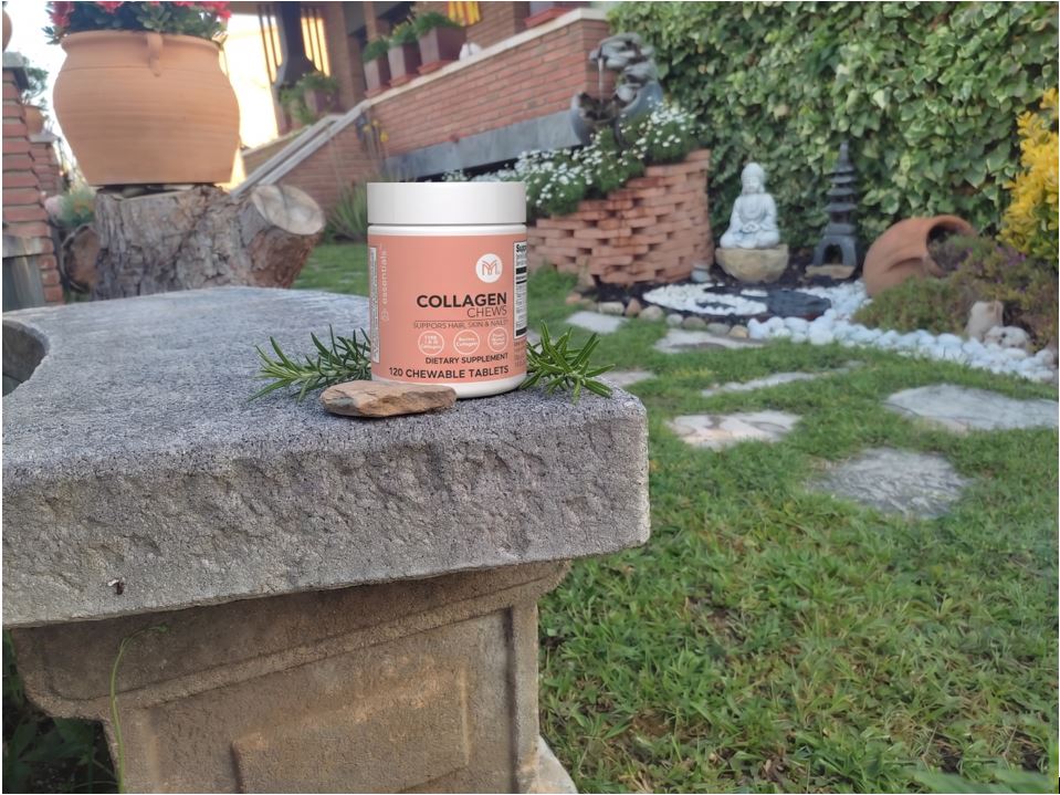 Pot de suplement de col·lagen mastegable de Mannatech sobre un banc de pedra en un jardí, ideal per millorar l'estructura de la pell i les articulacions.